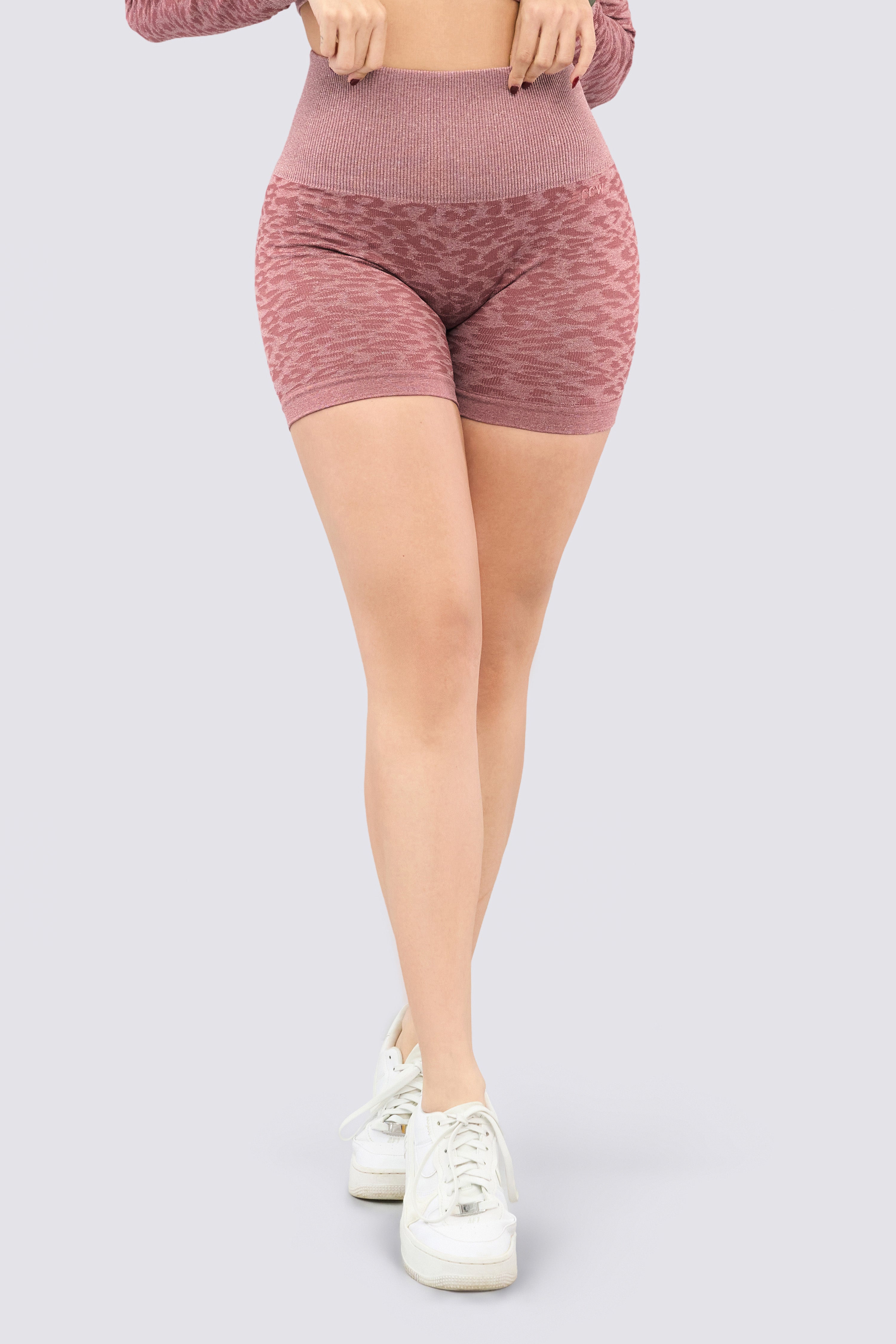 Pink sports shorts with animal print design, high waist, and ribbed waistband.
