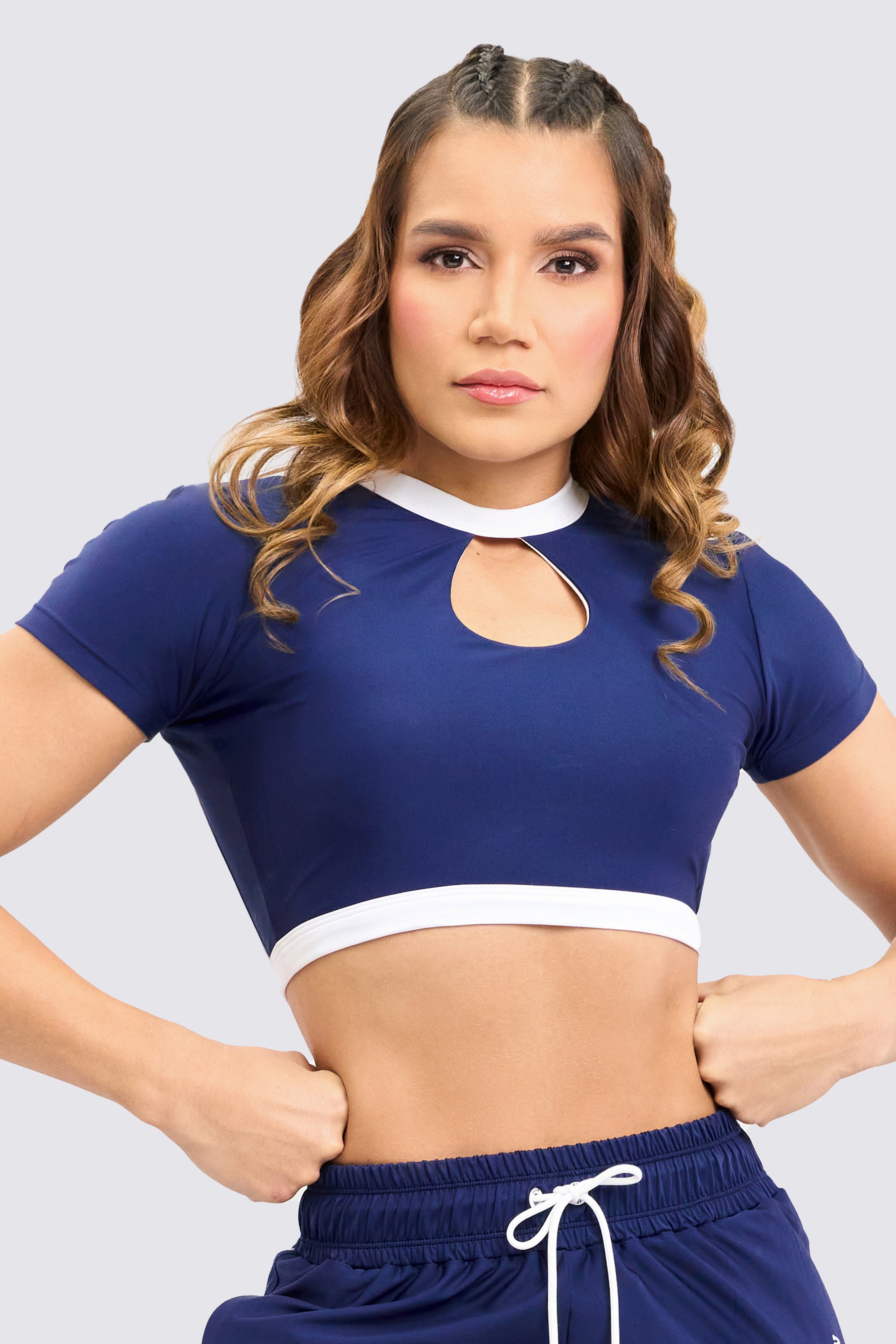 Crop Top deportivo color azul, con escote amplio en espalda, abertura en forma de gota frontal, y ribete en color blanco.